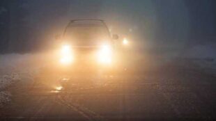 Car driving in rain with blinding headlights - copyright Elena Elisseeva