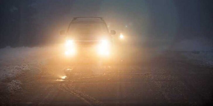 Car driving in rain with blinding headlights - copyright Elena Elisseeva