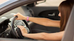 Young woman using her car horn. - Copyright: Syda
