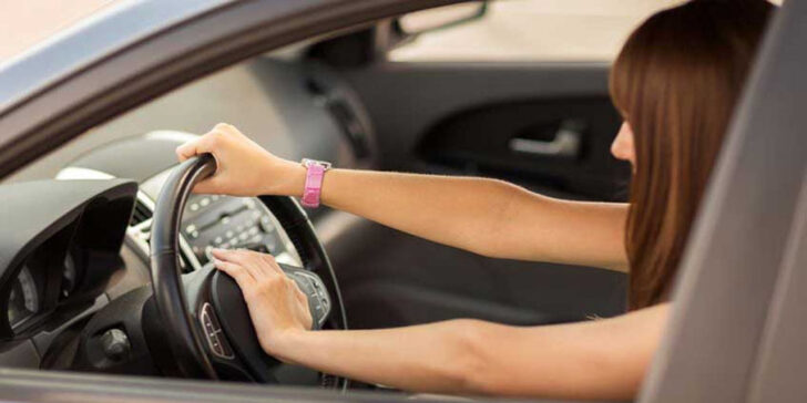 Young woman using her car horn. - Copyright: Syda